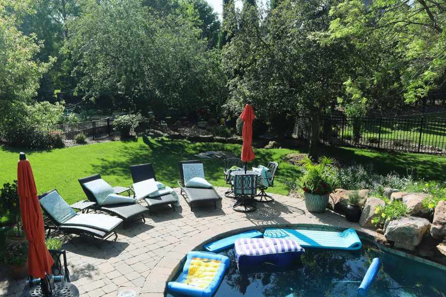 pool surrounded by a large lawn and nice landscaping