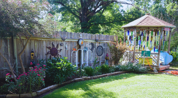 wood fense lined with blooming flowers and a gazebo
