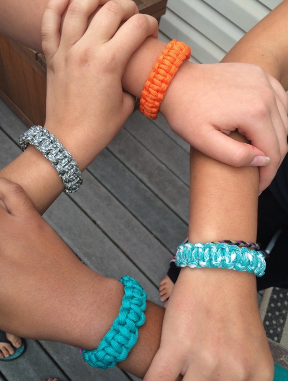 image of hands with bracelets joined together
